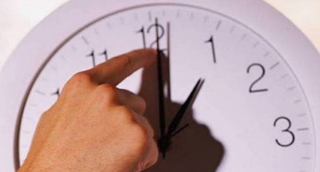 Mano cambiando hora en reloj